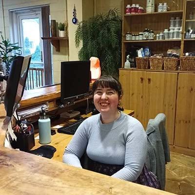 Smiling receptionist at natural products shop.